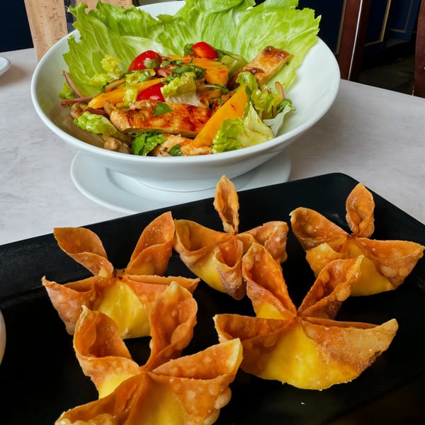Crispy crab wontons and a fresh Thai salad with chicken, mango, and cherry tomatoes.