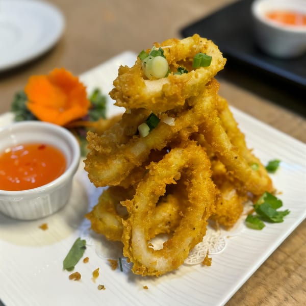 Golden fried calamari rings, garnished with green onions, served with sweet chili sauce.